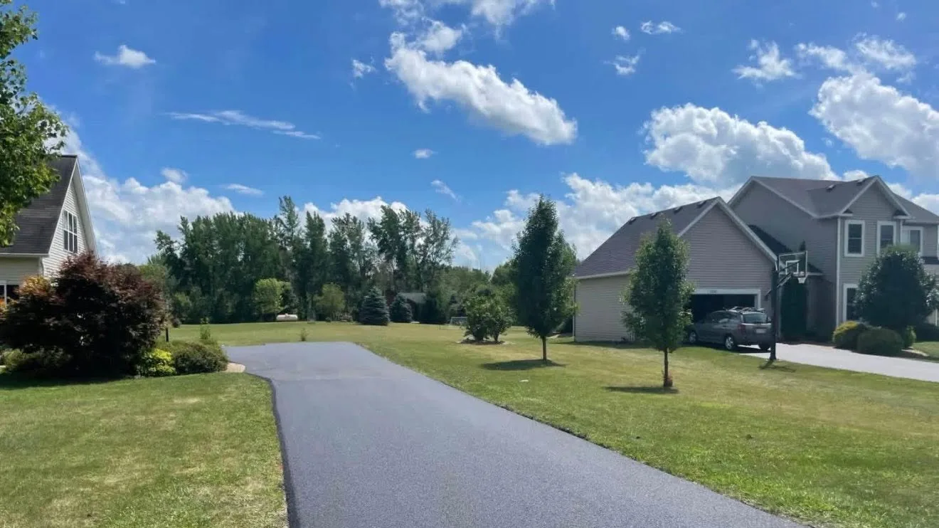Freshly paved asphalt driveway between lawns and homes, asphalt paving