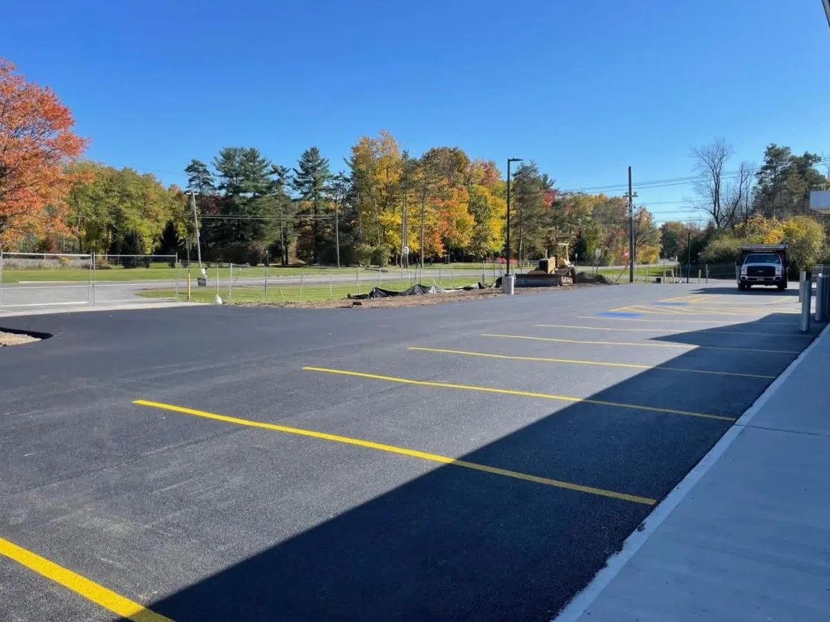New asphalt parking lot with fresh yellow striping, parking lot paving